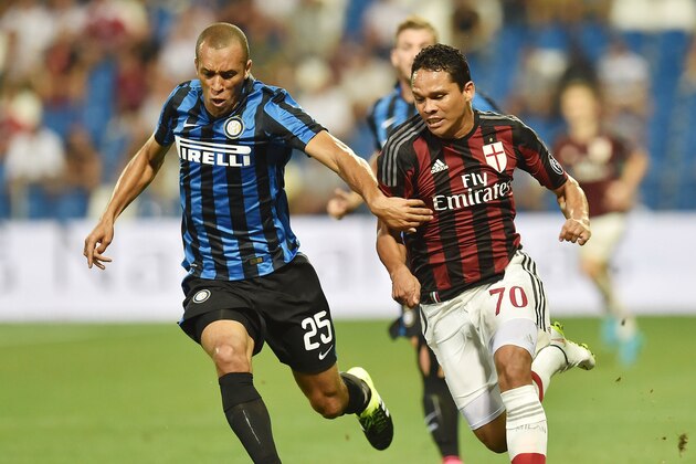 REGGIO NELL'EMILIA, ITALY - AUGUST 12: Joao Miranda of Internazionale and Carlos Bacca Ahumada of Milan in action during the TIM pre-season tournament match between AC Milan and FC Internazionale at Mapei Stadium - Città del Tricolore on August 12, 2015 in Reggio nell'Emilia, Italy.  (Photo by Giuseppe Bellini/Getty Images)