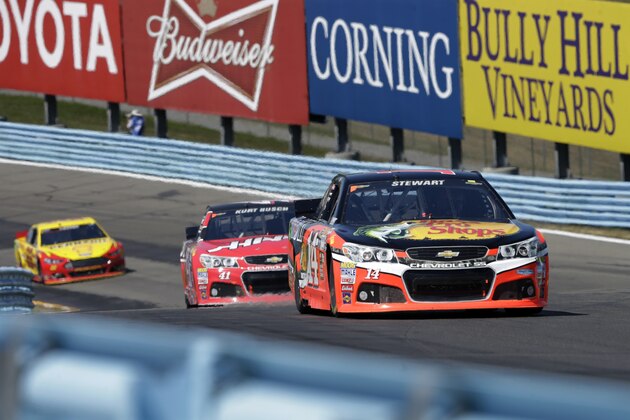 Tony Stewart (14) leads Kurt Busch (41)through the esses during a NASCAR Sprint Cup series auto race at Watkins Glen International, Sunday, Aug. 9, 2015, in Watkins Glen, N.Y. (AP Photo/Mel Evans)