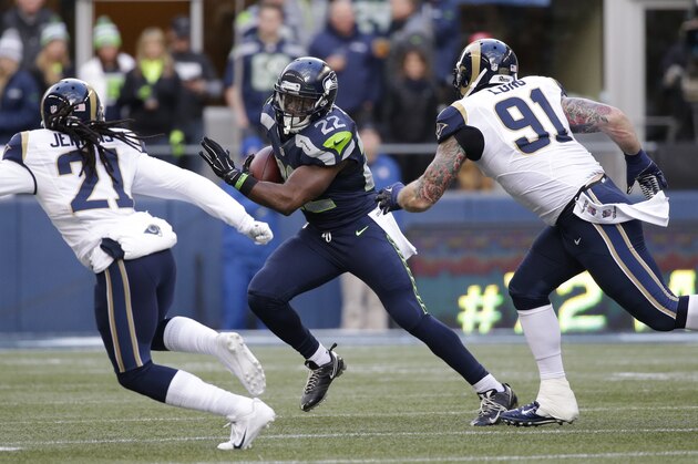 Seattle Seahawks running back Robert Turbin (22) rushes as St. Louis Rams' Chris Long (91) and Janoris Jenkins (21) pursue, in the first half of an NFL football game, Sunday, Dec. 28, 2014, in Seattle. (AP Photo/Elaine Thompson)