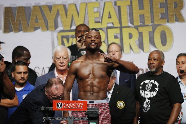 Floyd Mayweather Jr. poses on the scale during a weigh-in Friday, Sept. 11, 2015, in Las Vegas. Mayweather is scheduled to fight Andre Berto in a welterweight title bout Saturday in Las Vegas. (AP Photo/John Locher)