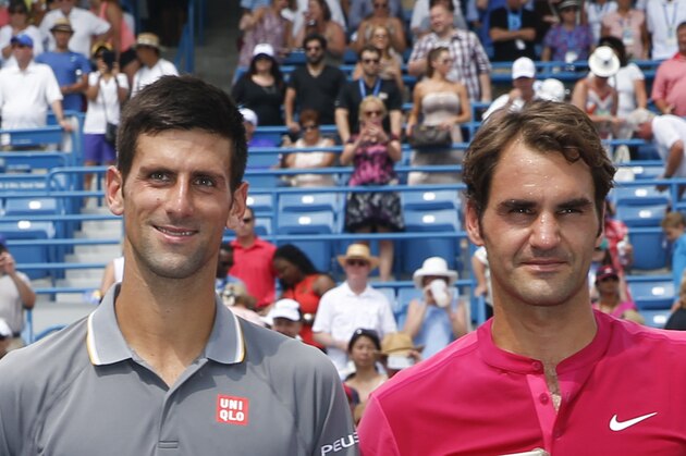 Roger Federer, right, of Switzerland, and Novak Djokovic, of Serbia, hold their trophies after the men's final at the Western & Southern Open tennis tournament, Sunday, Aug. 23, 2015, in Mason, Ohio. Federer defeated Djokovic 7-6 (1), 6-3. (AP Photo/John Minchillo)