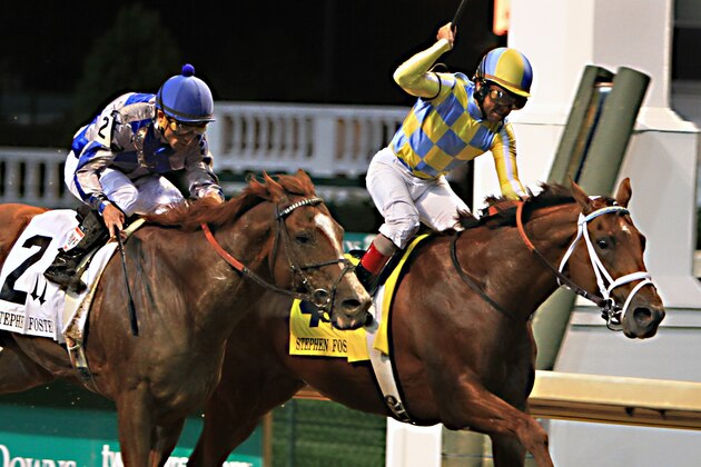 Jockey Shaun Bridgmohan, right, celebrates after guiding Noble Bird to a narrow victory over Lea, left, ridden by Joel Rosario, in the Stephen Foster Handicap horse race at Churchill Downs in Louisville, Ky., Saturday, June 13, 2015.  (AP Photo/Garry Jones)
