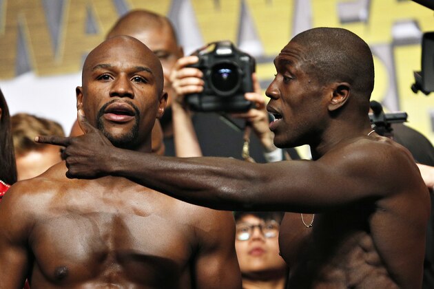 Floyd Mayweather Jr., left, and Andre Berto speak as they pose for photographers during weigh-ins Friday, Sept. 11, 2015, in Las Vegas. The two are scheduled to fight in a welterweight title bout Saturday in Las Vegas. (AP Photo/John Locher)