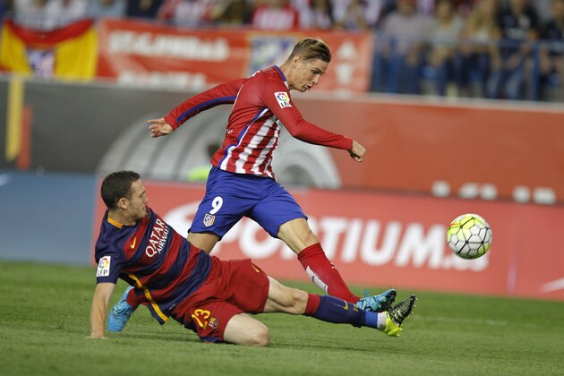 Atletico Madrid’s Fernando Torres, right, shoots past Barcelona’s Thomas Vermaelen during a Spanish La Liga soccer match between Atletico Madrid and Barcelona at the Vicente Calderon stadium in Madrid, Spain, Saturday Sept. 12, 2015. (AP Photo/Paul White)