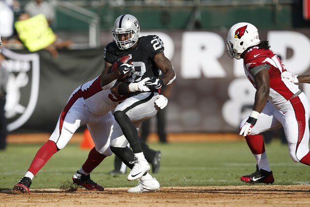 Oakland Raiders running back Latavius Murray (28) runs against Arizona Cardinals defensive end Calais Campbell, left, during the first half of an NFL preseason football game in Oakland, Calif., Sunday, Aug. 30, 2015. (AP Photo/Tony Avelar)
