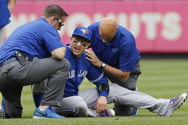 Toronto Blue Jays staff tend to Toronto Blue Jays shortstop Troy Tulowitzki, center, after he collided with Blue Jays center fielder Kevin Pillar fielding a fly ball in the second inning of a baseball game at Yankee Stadium in New York, Saturday, Sept. 12, 2015.  Tulowitzki left the game. (AP Photo/Kathy Willens)