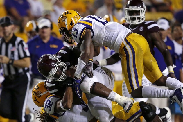 Mississippi State running back Josh Robinson is tackled by LSU cornerback Dwayne Thomas (13) and cornerback Jalen Collins (32) in the second half of an NCAA college football game in Baton Rouge, La., Saturday, Sept. 20, 2014. Mississippi State won 34-29. (AP Photo/Gerald Herbert)