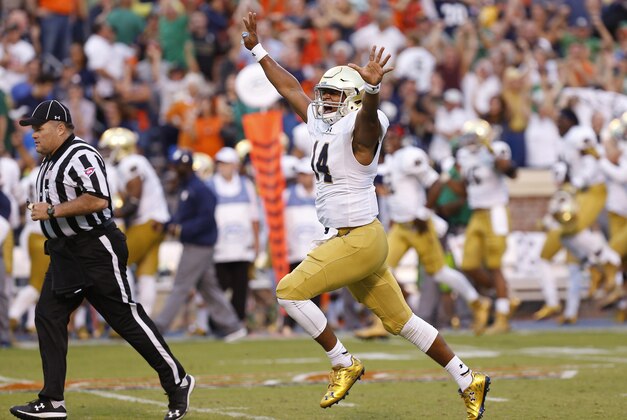 Sep 12, 2015; Charlottesville, VA, USA; Notre Dame Fighting Irish quarterback DeShone Kizer (14) celebrates after throwing the game-winning touchdown pass against the Virginia Cavaliers with twelve seconds left in the fourth quarter at Scott Stadium. The Fighting Irish won 34-27. Mandatory Credit: Geoff Burke-USA TODAY Sports