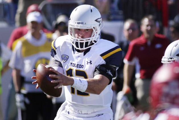 Toledo quarterback Phillip Ely takes the snap during the first half of an NCAA college football game against Arkansas in Little Rock, Ark., Saturday, Sept. 12, 2015. (AP Photo/Danny Johnston)