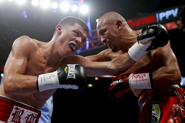 Roman Martinez, left, throws a left at Orlando Salido during their junior lightweight title boxing bout Saturday, Sept. 12, 2015, in Las Vegas. (AP Photo/Steve Marcus)