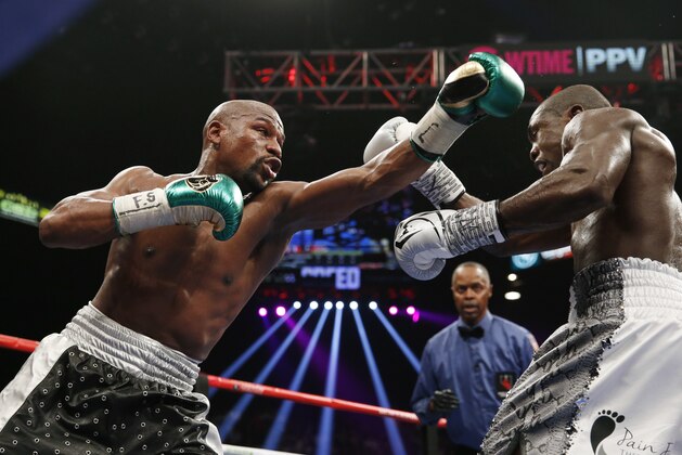 Floyd Mayweather Jr., left, throws a left at Andre Berto during their welterweight title boxing bout Saturday, Sept. 12, 2015, in Las Vegas. (AP Photo/John Locher)