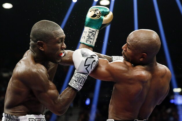Floyd Mayweather Jr., right, hits Andre Berto during their welterweight title boxing bout Saturday, Sept. 12, 2015, in Las Vegas. (AP Photo/Steve Marcus)