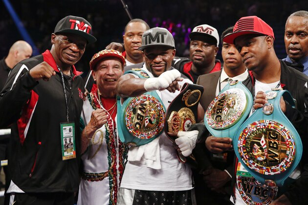 Floyd Mayweather Jr., center, celebrates after defeating Andre Berto during their welterweight title boxing bout Saturday, Sept. 12, 2015, in Las Vegas. (AP Photo/John Locher)