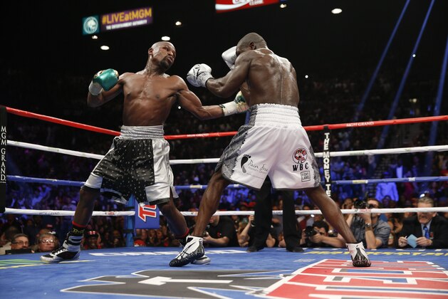 Floyd Mayweather Jr., right, hits Andre Berto during their welterweight title fight Saturday, Sept. 12, 2015, in Las Vegas. Mayweather, who won the fight, ran his perfect record to 49-0, tying a mark set by the late heavyweight champion Rocky Marciano. (AP Photo/Steve Marcus)