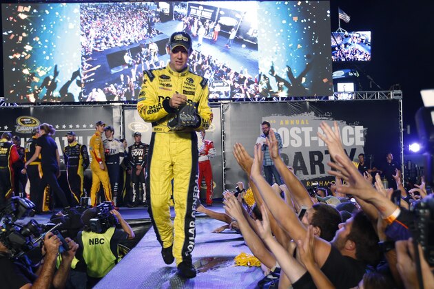 Matt Kenseth signs a hat for the crowd after the NASCAR Sprint Cup auto race, as drivers in the Chase for the Sprint Cup championship are introduced at Richmond International Raceway in Richmond, Va., Saturday, Sept. 12, 2015. (AP Photo/Chet Strange)