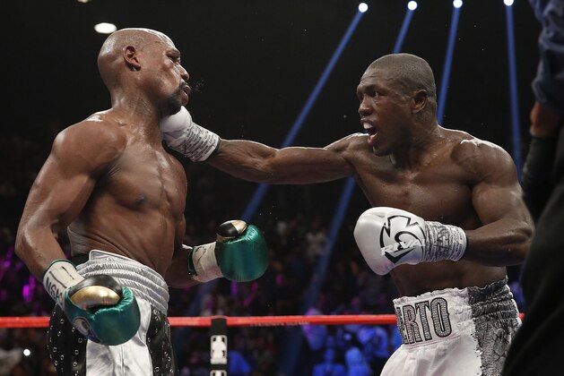 Andre Berto, right, punches Floyd Mayweather Jr. during their welterweight title fight Saturday, Sept. 12, 2015, in Las Vegas. (AP Photo/John Locher)