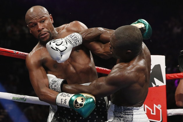 Andre Berto, right, punches Floyd Mayweather Jr. during their welterweight title boxing bout Saturday, Sept. 12, 2015, in Las Vegas. (AP Photo/John Locher)