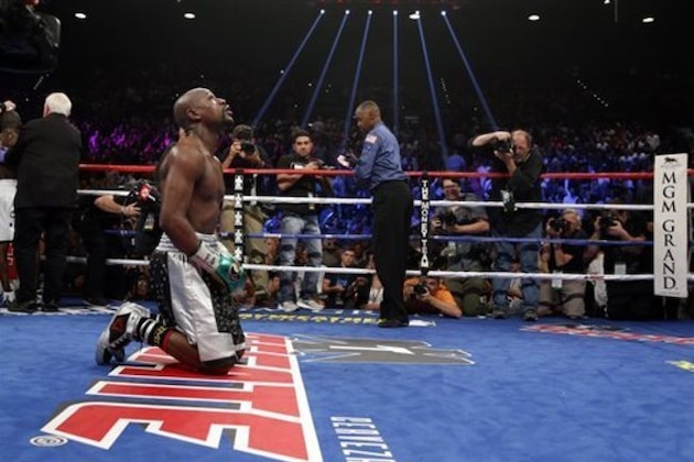 Floyd Mayweather Jr. kneels at the end of his welterweight title boxing bout against Andre Berto on Saturday, Sept. 12, 2015, in Las Vegas. (AP Photo/John Locher)