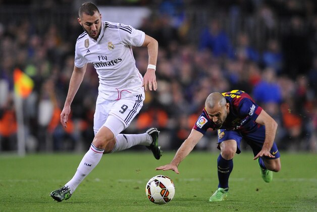 Real Madrid's Karim Benzema, left, takes the ball past Barcelona's Javier Mascherano during a Spanish La Liga soccer match between FC Barcelona and Real Madrid at Camp Nou stadium, in Barcelona, Spain, Sunday, March 22, 2015. (AP Photo/Manu Fernandez)