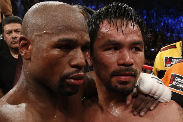 Floyd Mayweather Jr., hugs Manny Pacquiao after defeating Pacquiao in their welterweight unification bout on May 2, 2015 at the MGM Grand Garden Arena in Las Vegas, Nevada. AFP PHOTO / JOHN GURZINKSI        (Photo credit should read JOHN GURZINSKI/AFP/Getty Images)