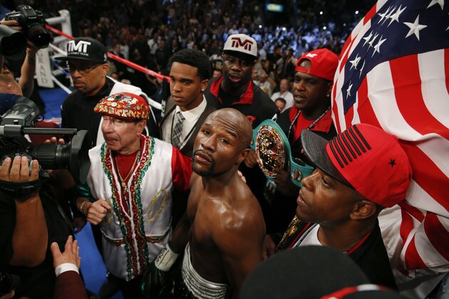 Floyd Mayweather Jr., center, waits for his welterweight title boxing bout against Andre Berto on Saturday, Sept. 12, 2015, in Las Vegas. (AP Photo/John Locher)