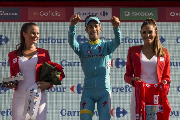 Astana's rider Fabio Aru from Italy celebrates on the podium after becoming the overall leader at the end of the 20th stage between San Lorenzo del Escorial and Cercedilla, 175,8 kilometers (109 miles), of the Spanish La Vuelta cycling tour in Cercedilla, Spain, Saturday, Sept. 12, 2015. (AP Photo/Daniel Ochoa de Olza)
