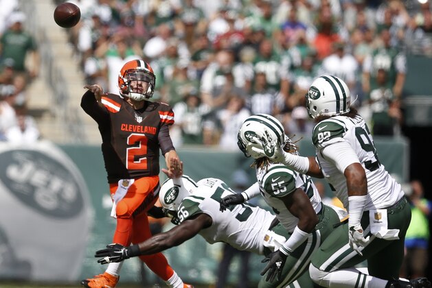 Cleveland Browns quarterback Johnny Manziel (2) throws a pass while evading New York Jets inside linebacker Demario Davis (56), Lorenzo Mauldin (55) and Kevin Vickerson (92) during the first half of an NFL football game Sunday, Sept. 13, 2015 in East Rutherford, N.J. (AP Photo/Kathy Willens)