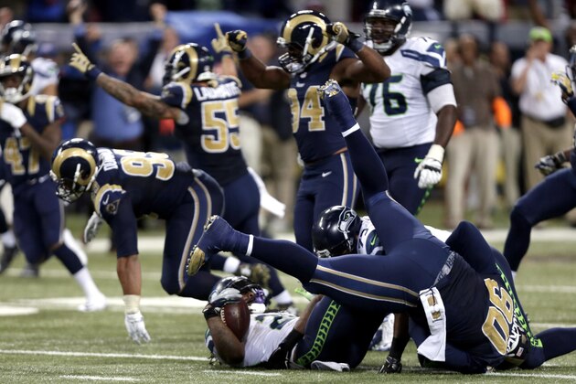 Seattle Seahawks running back Marshawn Lynch lands on his back as he is stopped on fourth down and St. Louis Rams players celebrate on the final play in overtime of an NFL football game Sunday, Sept. 13, 2015, in St. Louis. The Rams won 34-31. (AP Photo/Tom Gannam)