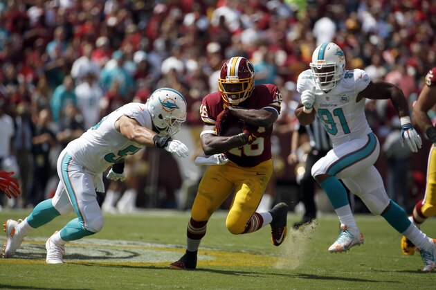 Washington Redskins running back Alfred Morris (46) tries to run away from Miami Dolphins outside linebacker Koa Misi (55)  and defensive end Cameron Wake (91) during the first half of an NFL football game Sunday, Sept. 13, 2015, in Landover, Md. (AP Photo/Evan Vucci)