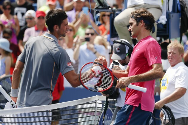 Roger Federer, right, of Switzerland, clasps hands with Novak Djokovic, of Serbia, after the men's final at the Western & Southern Open tennis tournament, Sunday, Aug. 23, 2015, in Mason, Ohio. Federer defeated Djokovic 7-6 (1), 6-3. (AP Photo/John Minchillo)