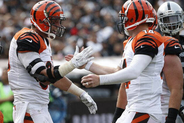 Cincinnati Bengals tight end Tyler Eifert (85) and quarterback Andy Dalton (14) celebrate after connecting on a 13-yard touchdown pass against the Oakland Raiders during the first half of an NFL football game in Oakland, Calif., Sunday, Sept. 13, 2015. (AP Photo/Tony Avelar)