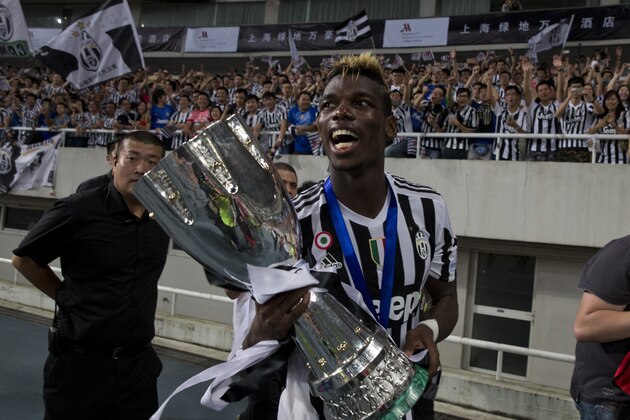 Juventus' Paul Labile Pogba celebrates with the trophy after the team won against Lazio during the 2015 TIM Italian Supercup held at the Shanghai Stadium in Shanghai, China, Saturday, Aug. 8, 2015. Juventus defeat Lazio 2-0 to win the Supercup. (AP Photo/Ng Han Guan)
