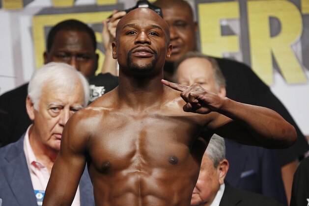 Floyd Mayweather Jr. poses on the scale during a weigh-in Friday, Sept. 11, 2015, in Las Vegas. Mayweather is scheduled to fight Andre Berto in a welterweight title bout Saturday in Las Vegas. (AP Photo/John Locher)