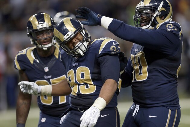 St. Louis Rams defensive tackle Aaron Donald, center, is congratulated by teammates Michael Brockers, right, and defensive end Eugene Sims after sacking Seattle Seahawks quarterback Russell Wilson for a 4-yard loss during the third quarter of an NFL football game Sunday, Sept. 13, 2015, in St. Louis. (AP Photo/Tom Gannam)