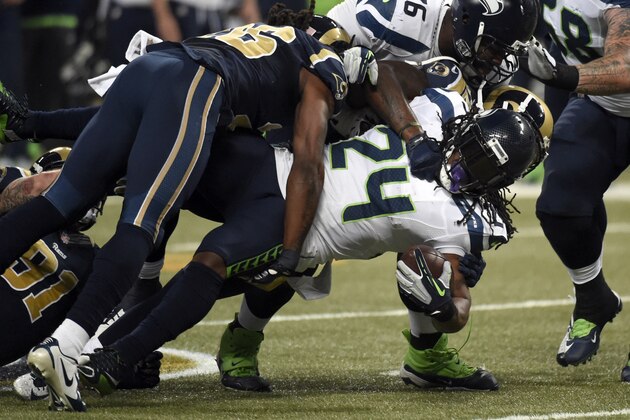 Seattle Seahawks running back Marshawn Lynch, right, struggles for yardage before being brought down by St. Louis Rams strong safety Mark Barron, left, during the first quarter of an NFL football game Sunday, Sept. 13, 2015, in St. Louis. (AP Photo/L.G. Patterson)