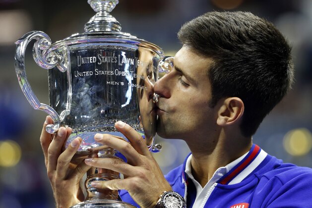 Novak Djokovic, of Serbia, kisses the championship trophy after defeating Roger Federer, of Switzerland, during the men's championship match of the U.S. Open tennis tournament, Sunday, Sept. 13, 2015, in New York. (AP Photo/Julio Cortez)