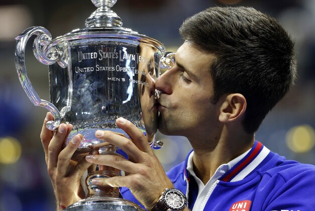 Novak Djokovic, of Serbia, kisses the championship trophy after defeating Roger Federer, of Switzerland, during the men's championship match of the U.S. Open tennis tournament, Sunday, Sept. 13, 2015, in New York. (AP Photo/Julio Cortez)