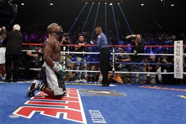Floyd Mayweather Jr. kneels at the end of his welterweight title boxing bout against Andre Berto on Saturday, Sept. 12, 2015, in Las Vegas. (AP Photo/John Locher)