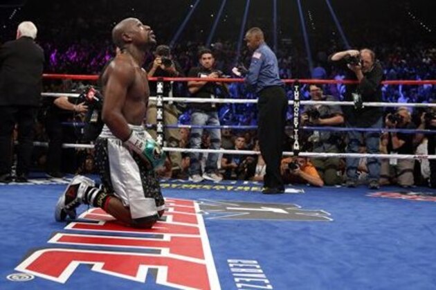 Floyd Mayweather Jr. kneels at the end of his welterweight title boxing bout against Andre Berto on Saturday, Sept. 12, 2015, in Las Vegas. (AP Photo/John Locher)