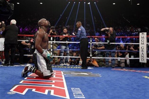 Floyd Mayweather Jr. kneels at the end of his welterweight title boxing bout against Andre Berto on Saturday, Sept. 12, 2015, in Las Vegas. (AP Photo/John Locher)