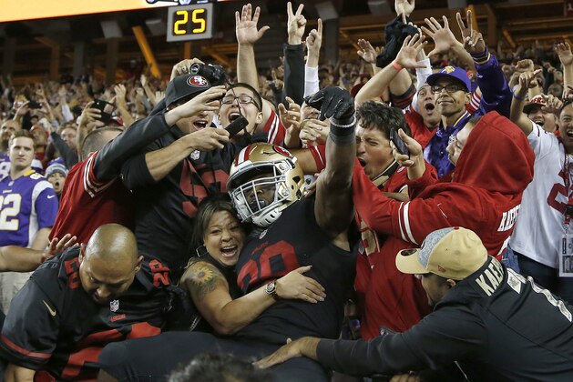 San Francisco 49ers running back Carlos Hyde, center, celebrates with fans after scoring on a 17-yard touchdown run against the Minnesota Vikings during the second half of an NFL football game in Santa Clara, Calif., Monday, Sept. 14, 2015. (AP Photo/Tony Avelar)