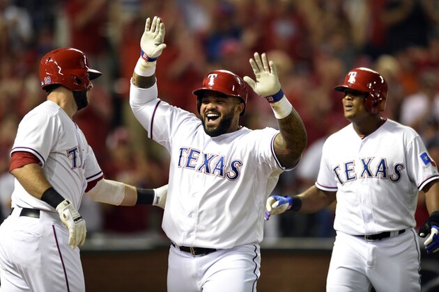 Prince Fielder (centro), de los Rangers de Texas, es felicitado por sus compañeros Mitch Moreland (izquierda) y el dominicano Adrián Beltré, luego de conectar un jonrón de dos carreras frente a los Astros de Houston, el lunes 14 de septiembre de 2015 (AP Foto/Jeffrey McWhorter)