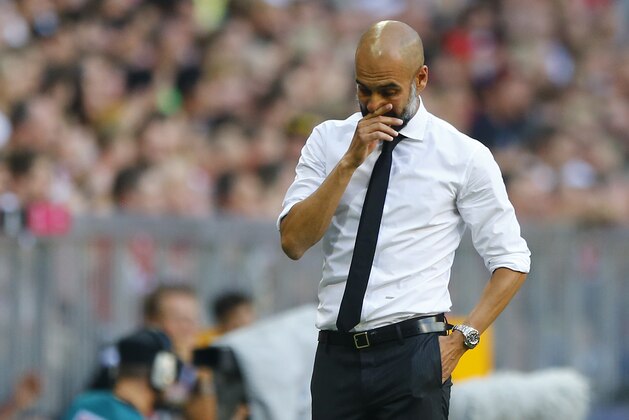 Bayern coach Pep Guardiola covers his face during the German Bundesliga soccer match between FC Bayern Munich and Bayer Leverkusen 04 in Munich, Germany, Saturday, Aug. 29, 2015. (AP Photo/Matthias Schrader)