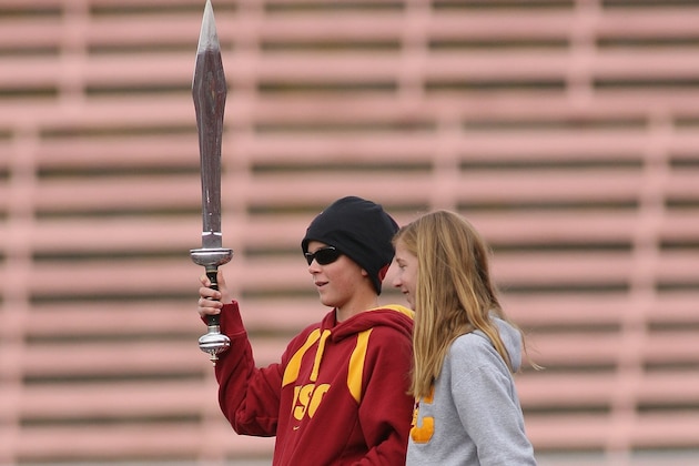 LOS ANGELES, CA - DECEMBER 5:  Jake Olson and Emma Olson lead the Trojan Marching Band during the game between the Arizona Wildcats and the USC Trojans on December 5, 2009 at the Los Angeles Coliseum in Los Angeles, California.  Jake was a guest of the team and is a huge USC fan who lost his eyesight to cancer.  Arizona won 21-17.  (Photo by Jeff Golden/Getty Images)