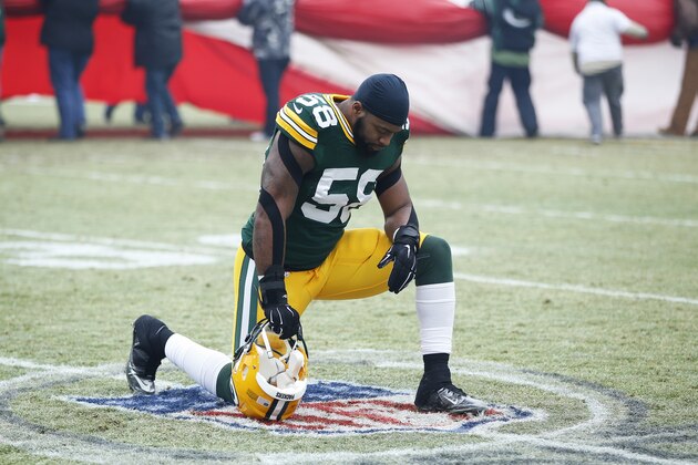GREEN BAY, WI - JANUARY 11: Sam Barrington #58 of the Green Bay Packers kneels to pray on the NFL logo before the NFC Divisional Playoff game against the Dallas Cowboys at Lambeau Field on January 11, 2015 in Green Bay, Wisconsin. The Packers defeated the Cowboys 26-21. (Photo by Joe Robbins/Getty Images)