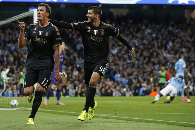 Juventus' Mario Mandzukic celebrates with Alvaro Morata  after scoring a goal during the Champions League group D soccer match between Manchester City and Juventus at the Etihad Stadium, Manchester, England, Tuesday, Sept. 15, 2015. (AP Photo/Jon Super)