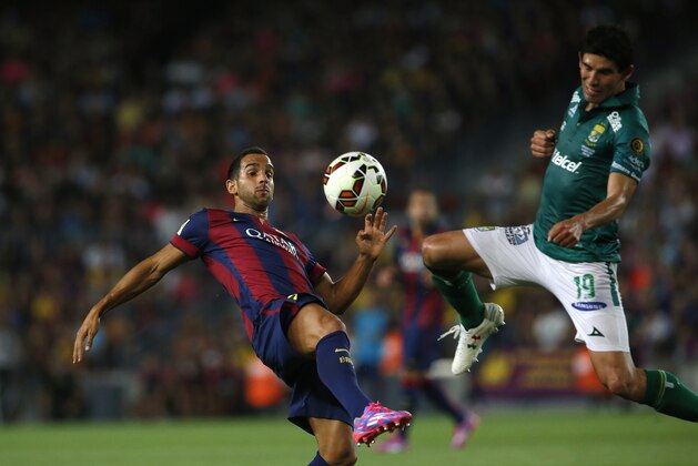 Barcelona's Martin Montoya fights for the ball against Leon's Jonny Magallon during the Joan Gamper trophy friendly soccer match between Barcelona and Leon at the Camp Nou stadium in Barcelona, Spain, Monday, Aug. 18, 2014. (AP Photo/Emilio Morenatti)