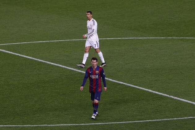 Barcelona's Argentinian forward Lionel Messi (DOWN)  and Real Madrid's Portuguese forward Cristiano Ronaldo walk on the field during the 'clasico' Spanish league football match FC Barcelona vs Real Madrid CF at the Camp Nou stadium in Barcelona on March 22, 2015. AFP PHOTO / QUIQUE GARCIA        (Photo credit should read QUIQUE GARCIA/AFP/Getty Images)