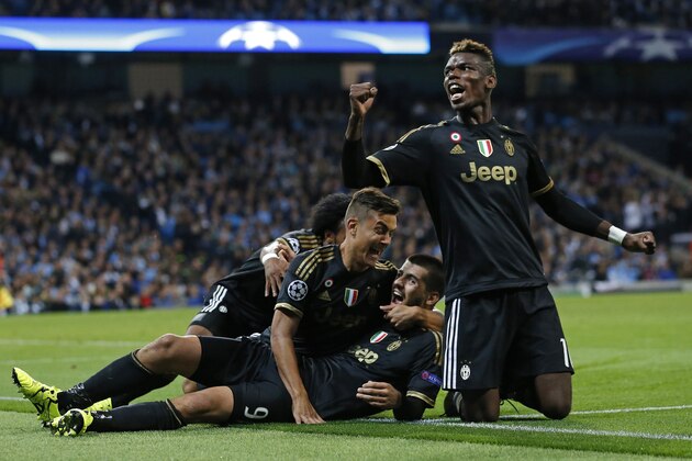 Juventus' Alvaro Morata, centre, celebrates with teammates including Paul Pogba, right, after scoring his sides second goal during the Champions League group D soccer match between Manchester City and Juventus at the Etihad Stadium, Manchester, England, Tuesday, Sept. 15, 2015. (AP Photo/Jon Super)