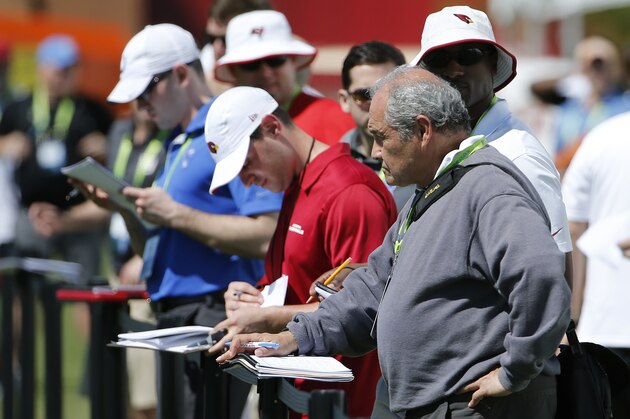 Scouts from a variety of NFL teams watch players during NFL Super Regional Combine football workout drills Saturday, March 21, 2015, in Tempe, Ariz. (AP Photo/Ross D. Franklin)